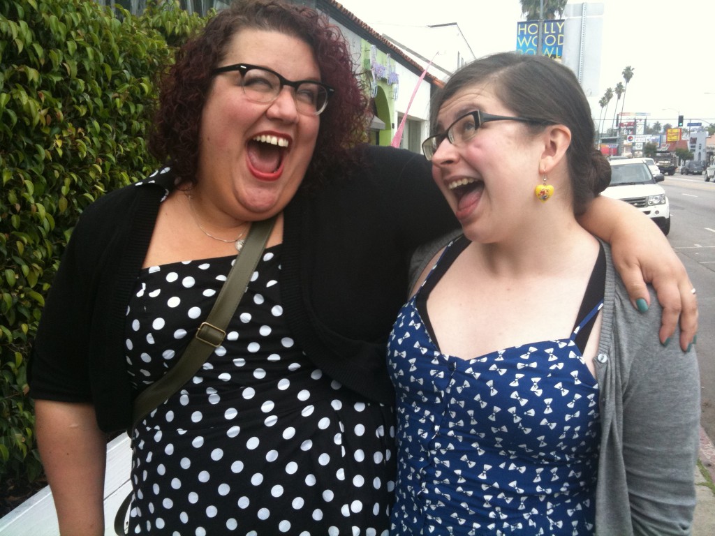 Me and Savannah Dooley, making silly open-mouthed-smile faces, and dressed in a startlingly similar fashion, in printed dresses and cardigans.